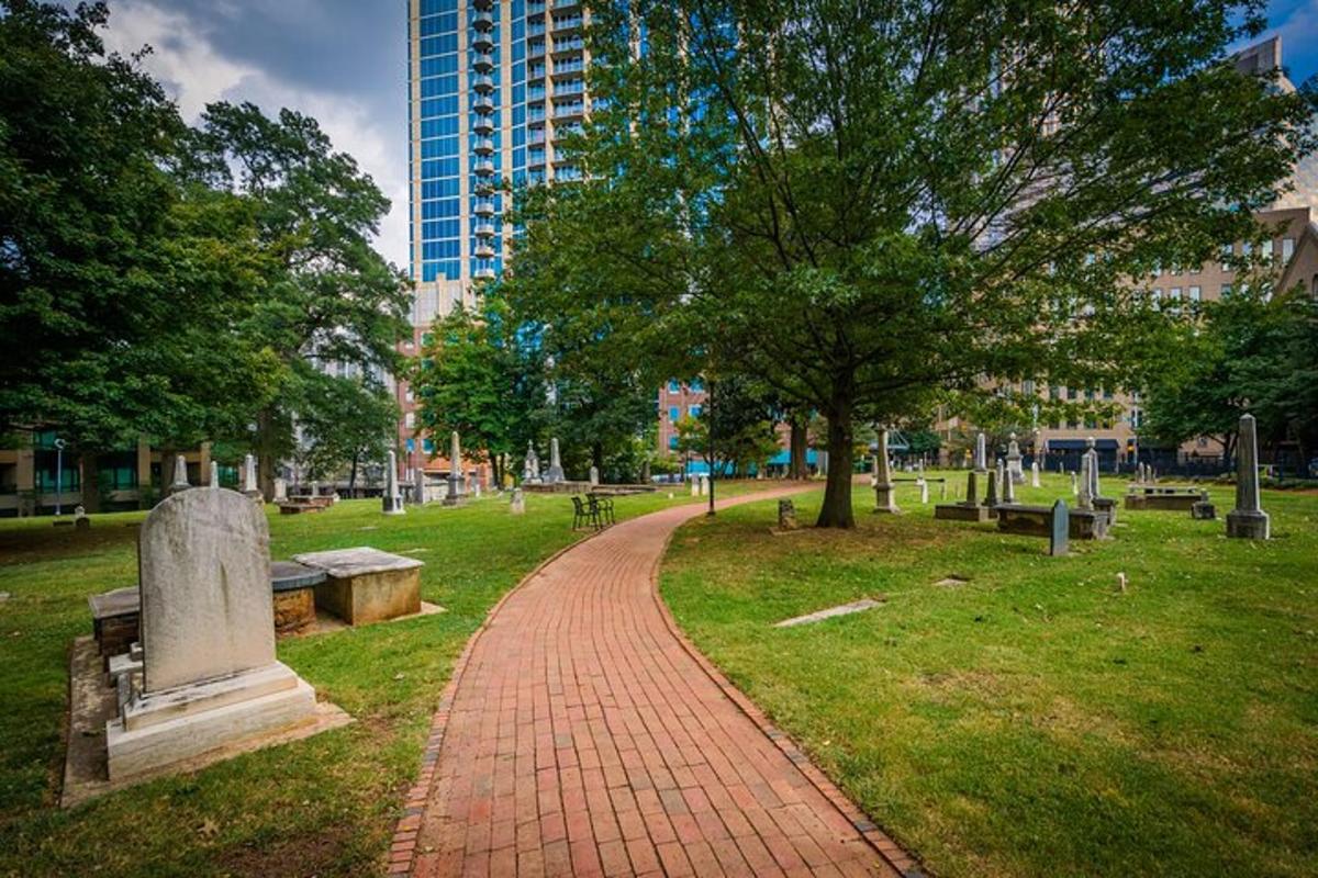a brick path in a park with trees and benches