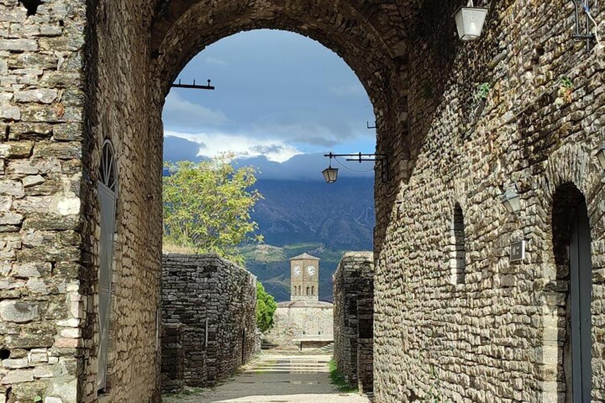 an archway in an old stone building with a tower in the distance