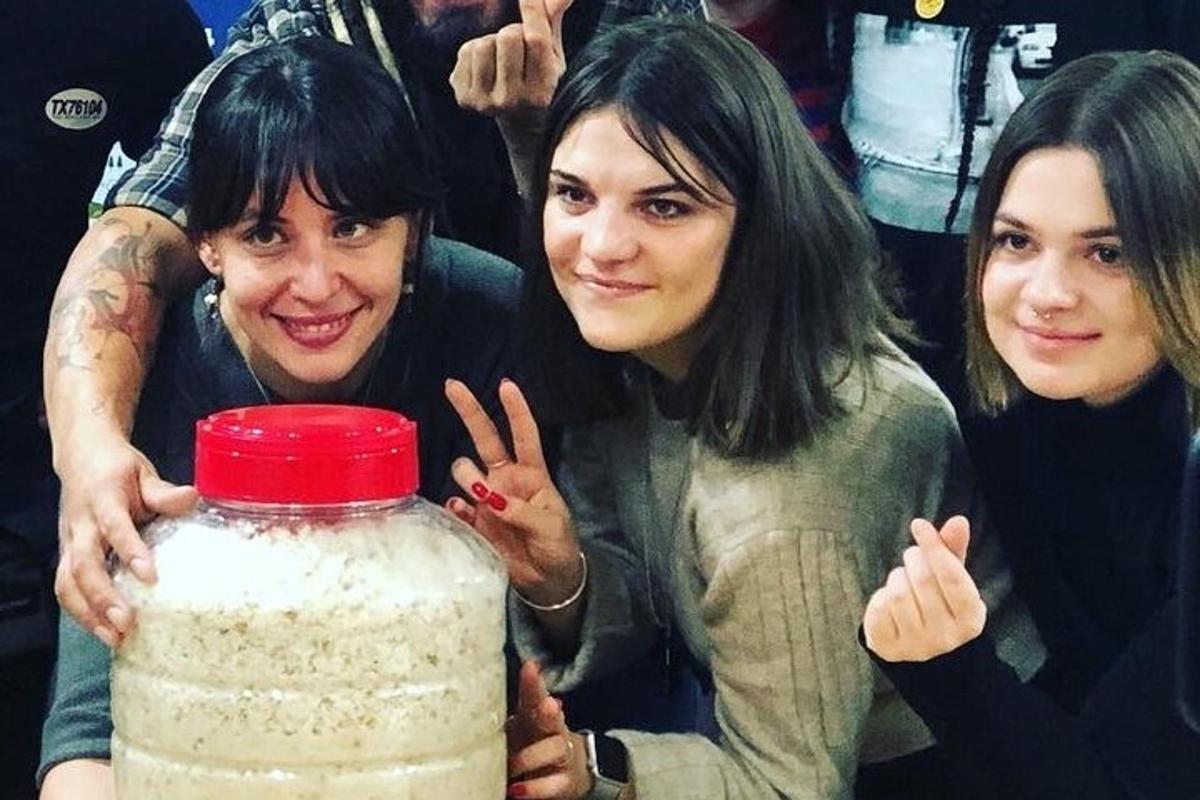three women standing next to a jar of oatmeal