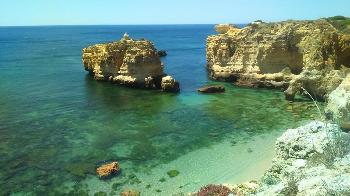 a view of a beach with rocks in the water