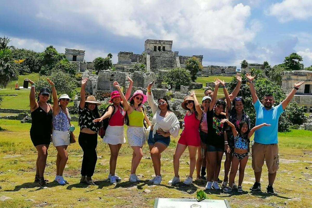 Un grupo de personas posando para una foto frente a una ruina.