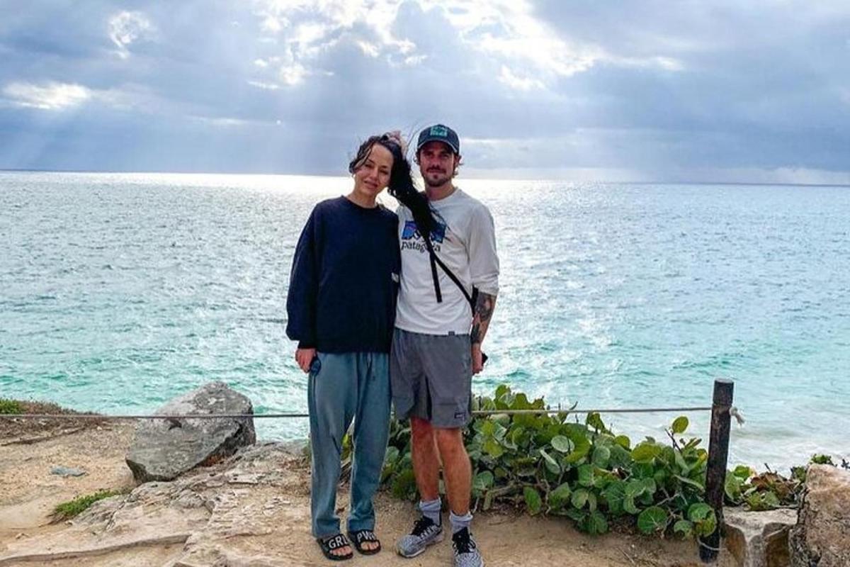 a man and a woman standing next to the ocean