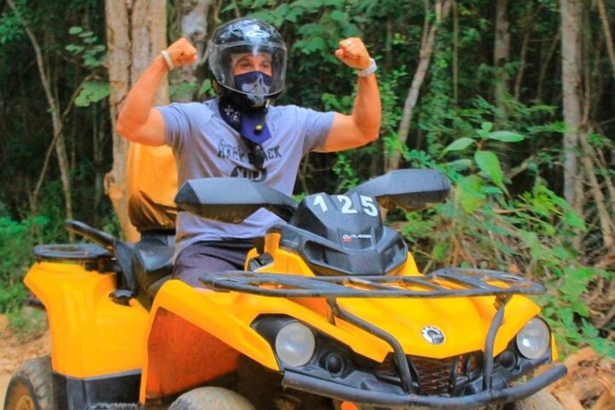 egy férfi egy ATV-n, ököllel a magasba