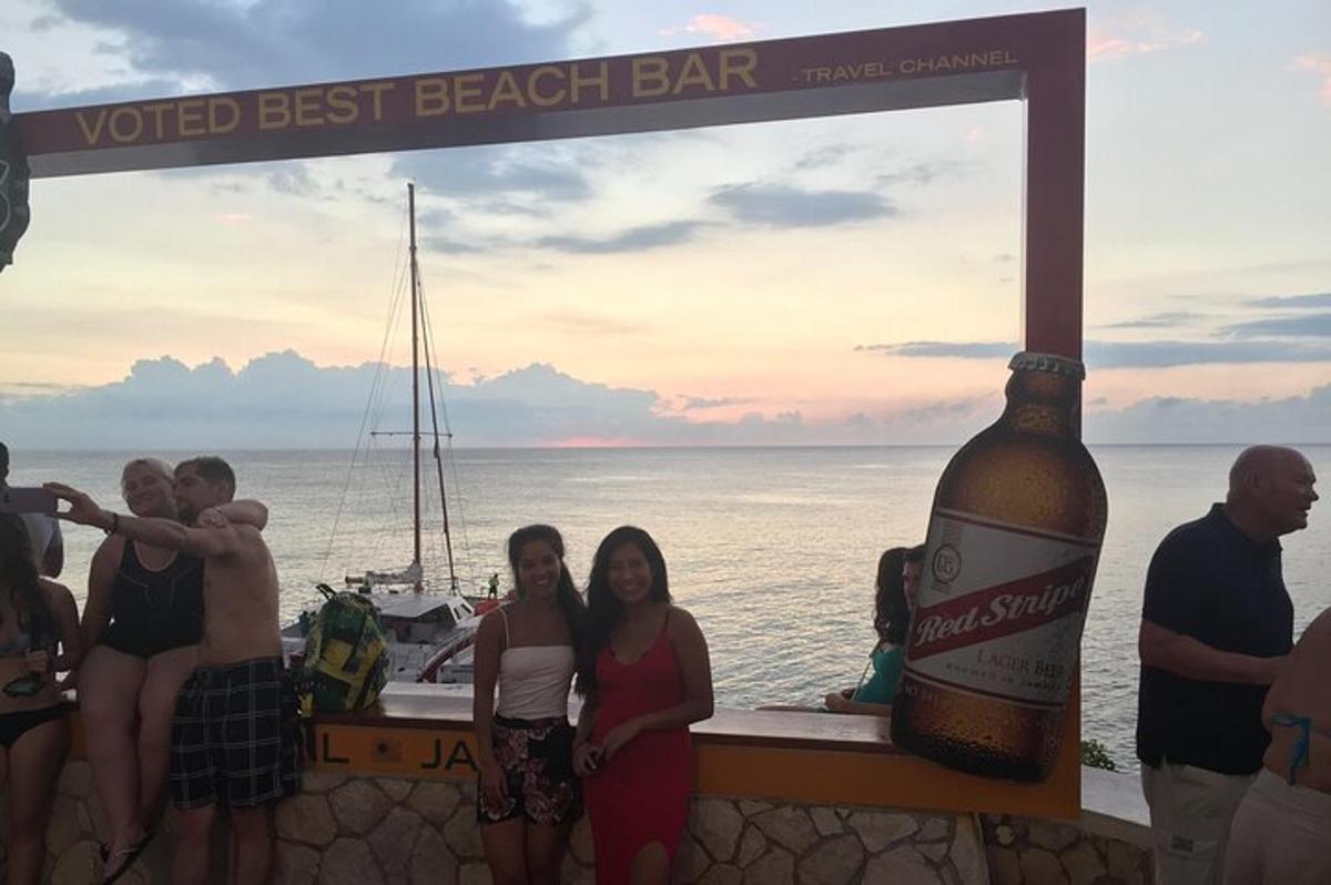 um grupo de pessoas em pé ao lado de uma garrafa de cerveja