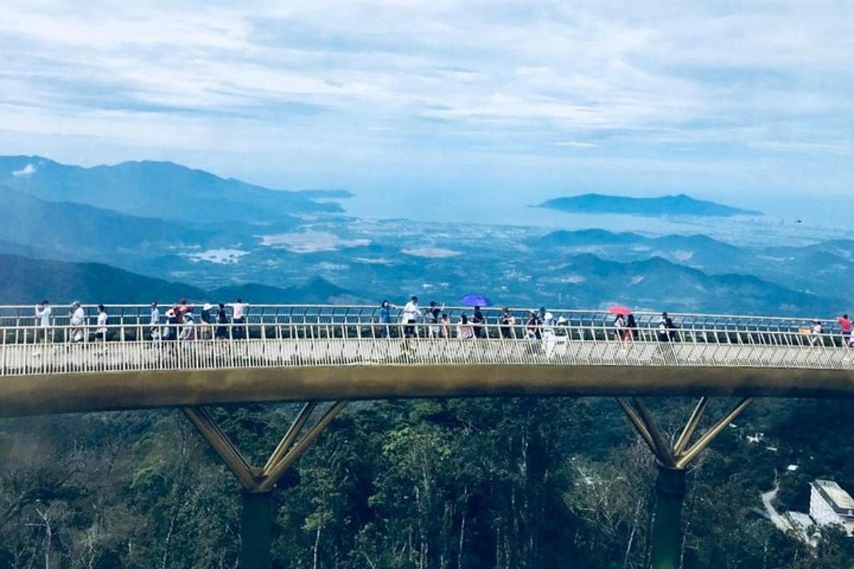 un grup de persones caminant per un pont a les muntanyes