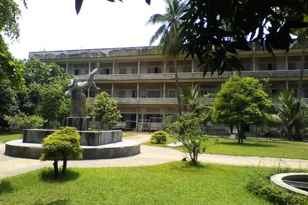 un edificio con una estatua en medio de un parque