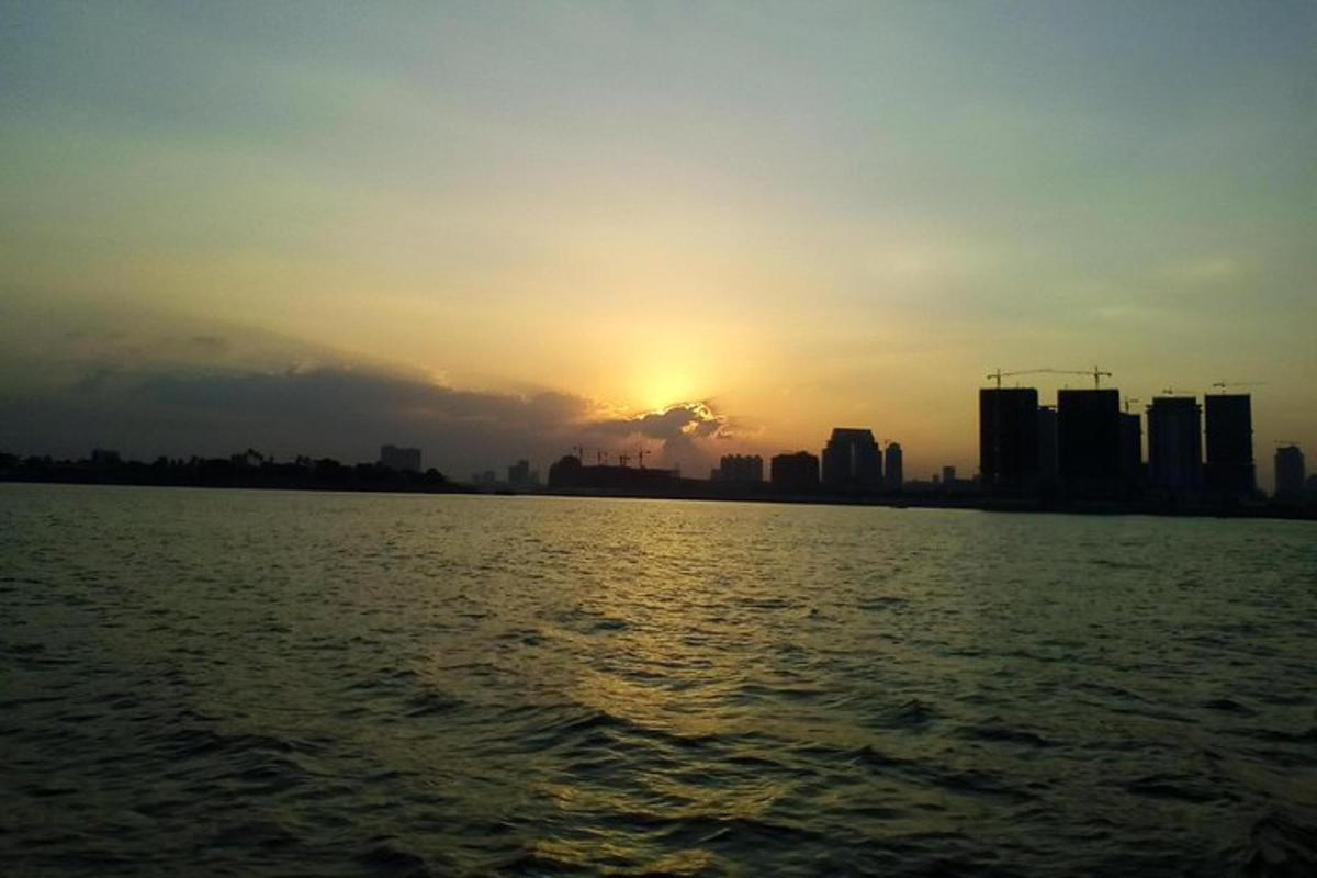 a sunset over a large body of water with buildings