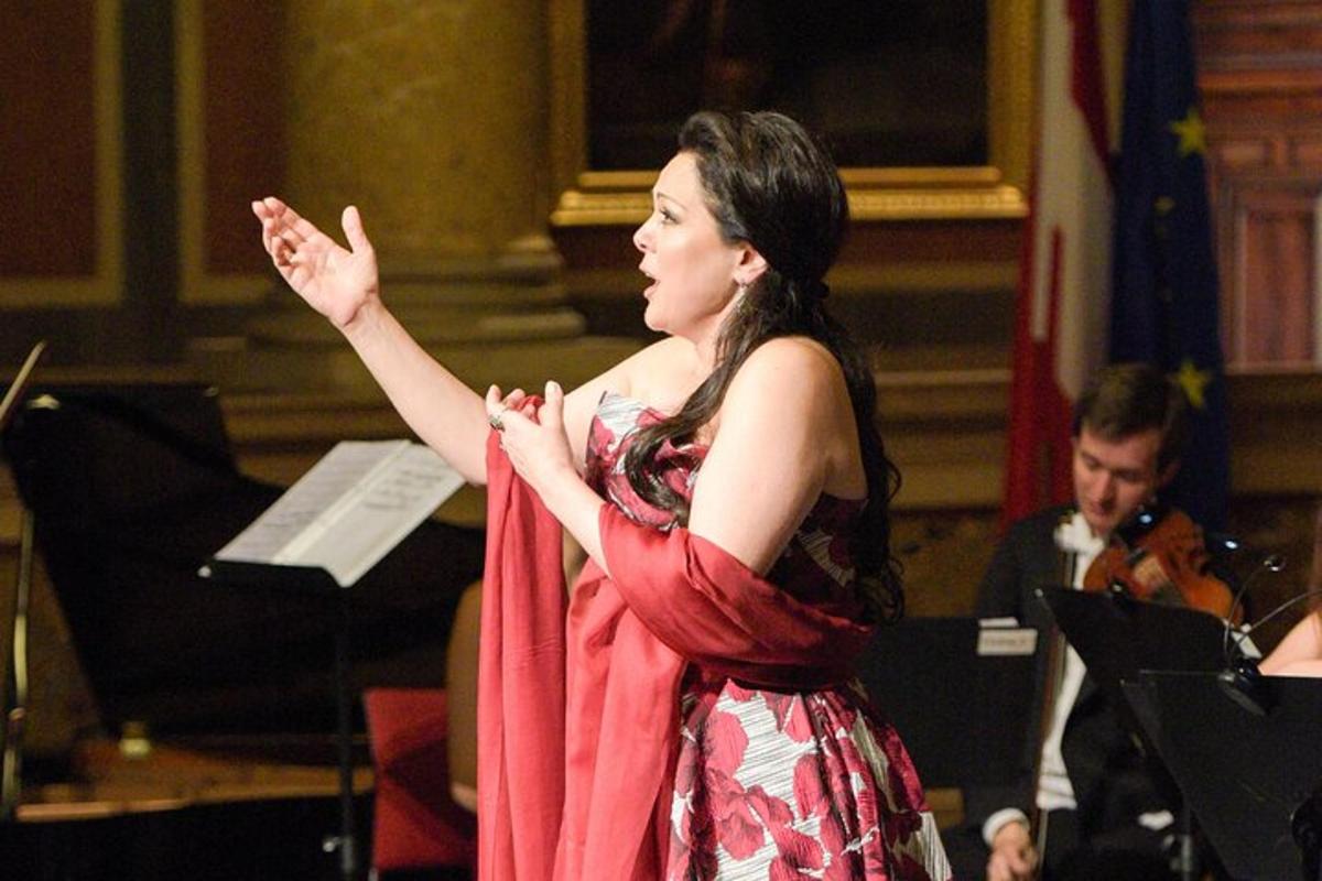 una dona dreta davant d'un concert amb les mans enlaire
