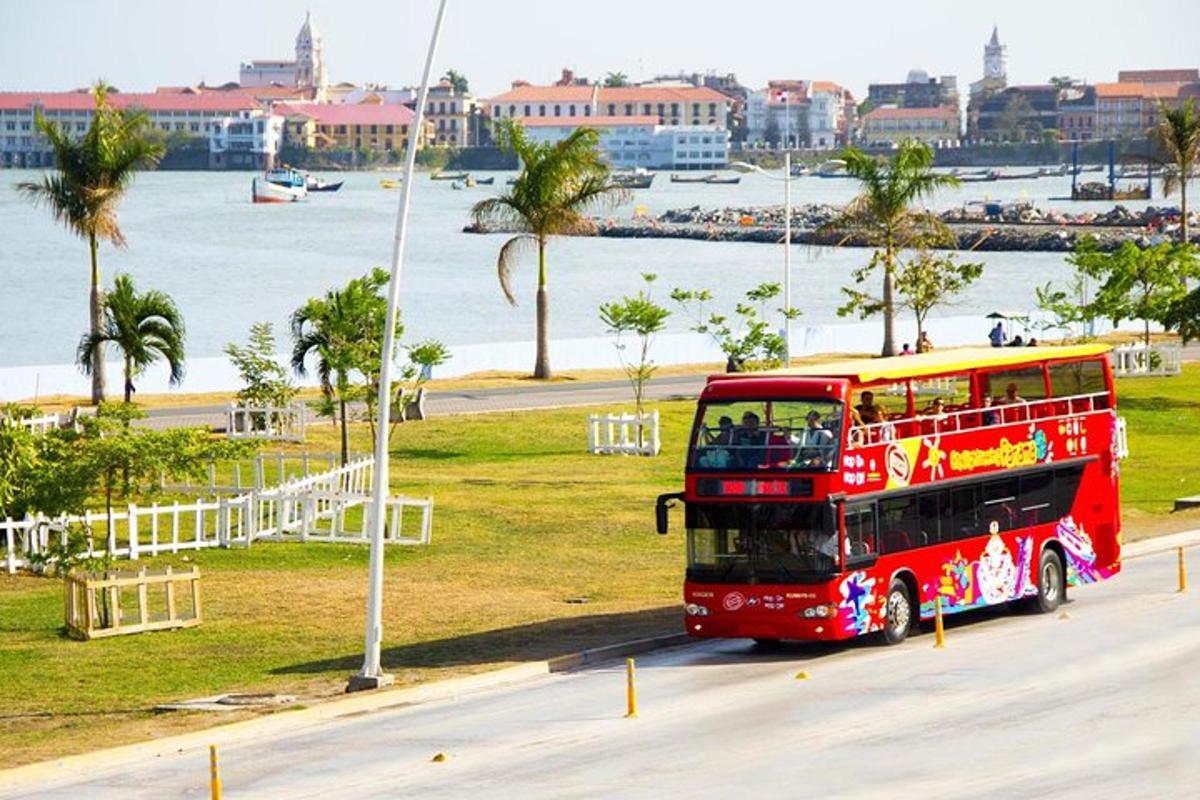 a red double decker bus driving down a street