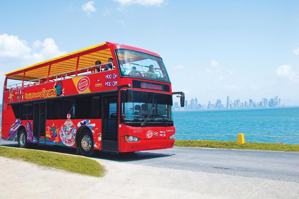 a red double decker bus driving down a street