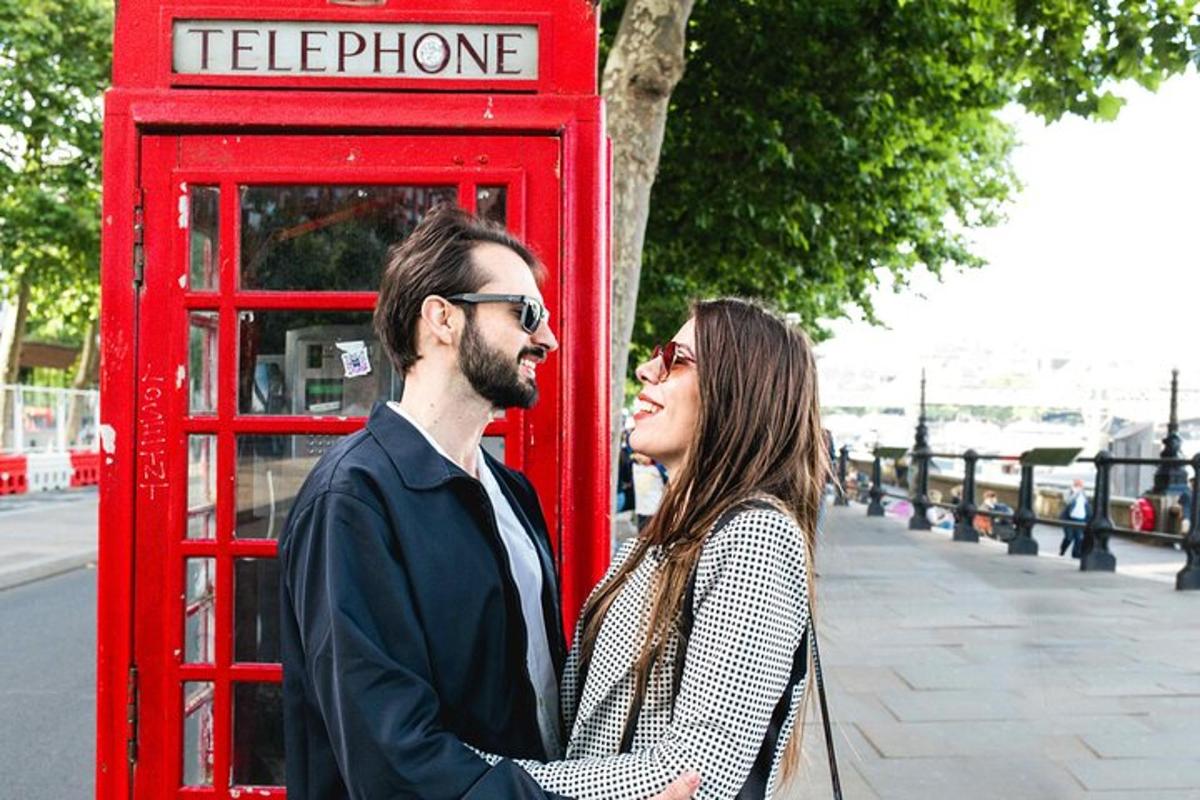 muž a žena stojící vedle červené telefonní budky