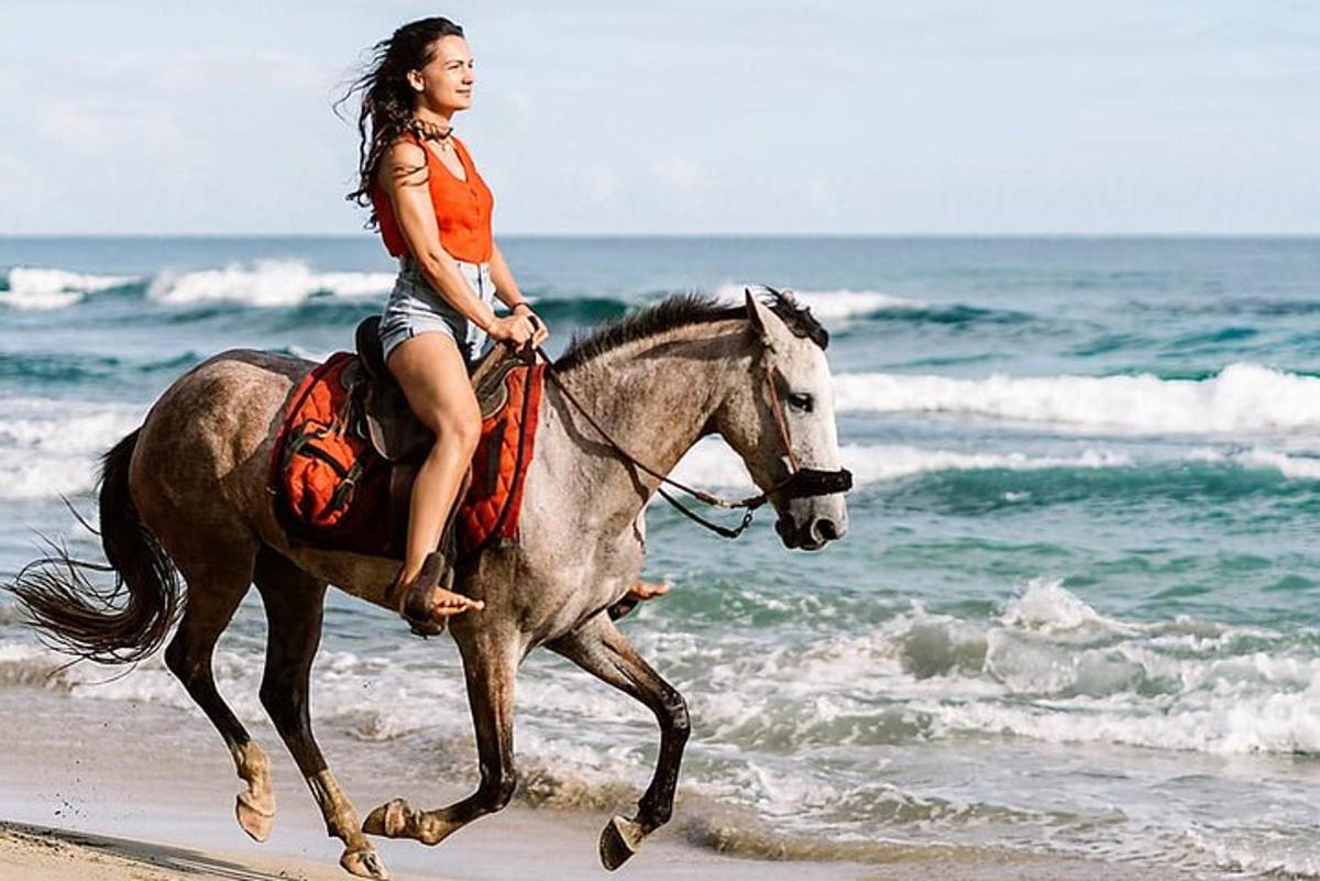 una mujer montando a caballo en la playa