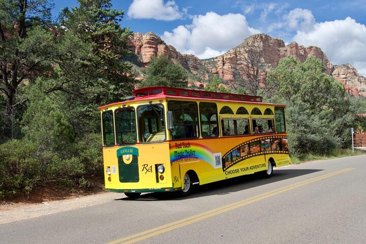 a yellow trolley car driving down a road