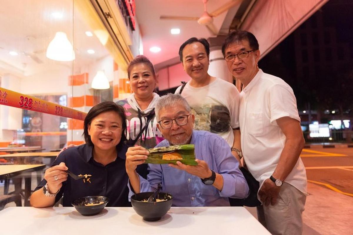一群人围着桌子站着，手里拿着一盘食物