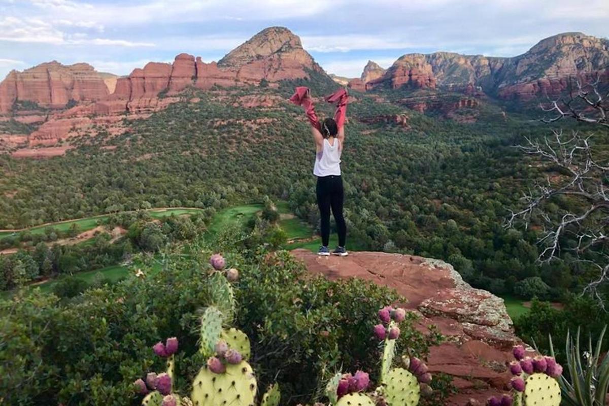 una donna in piedi su una roccia con le mani in aria