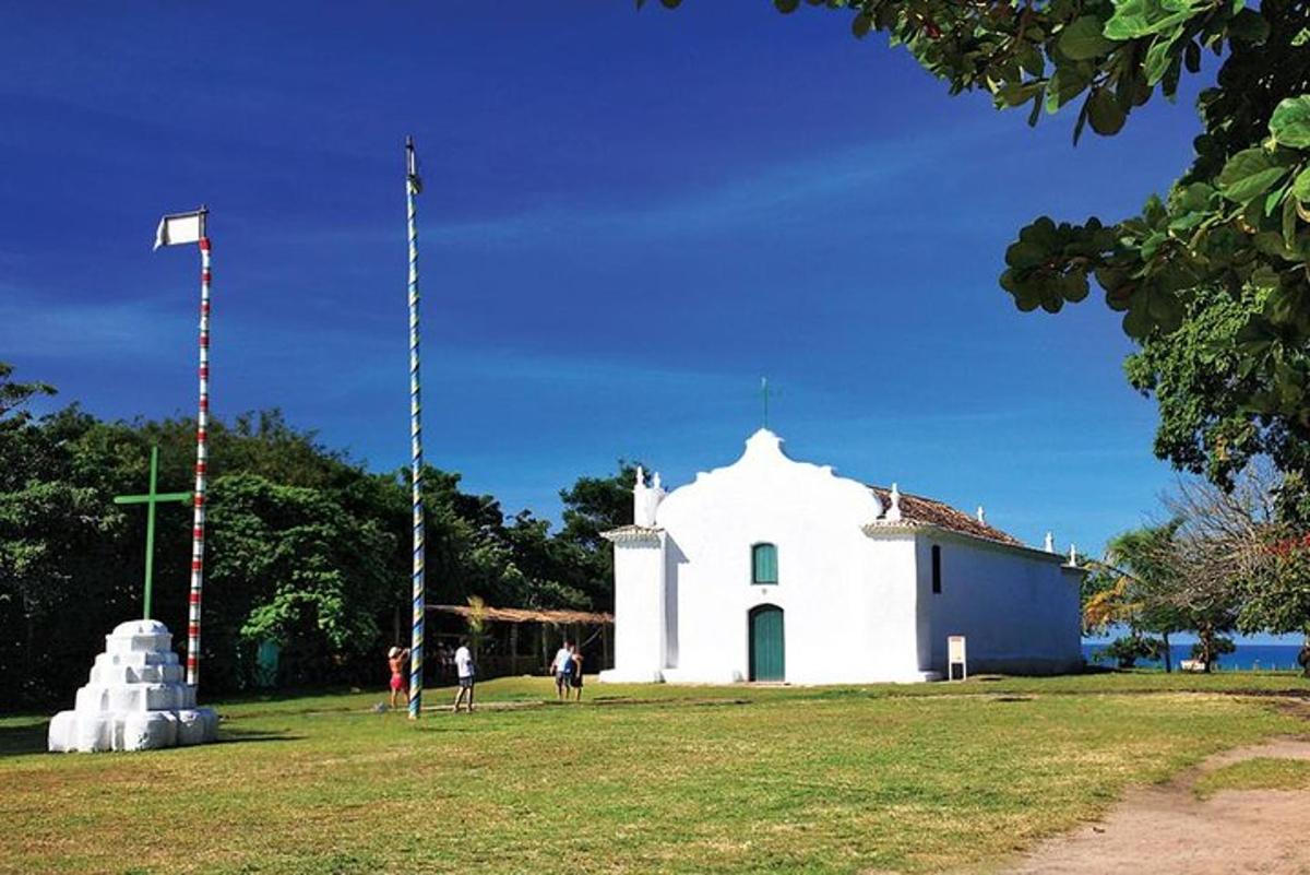 a small white church with people standing in front of it