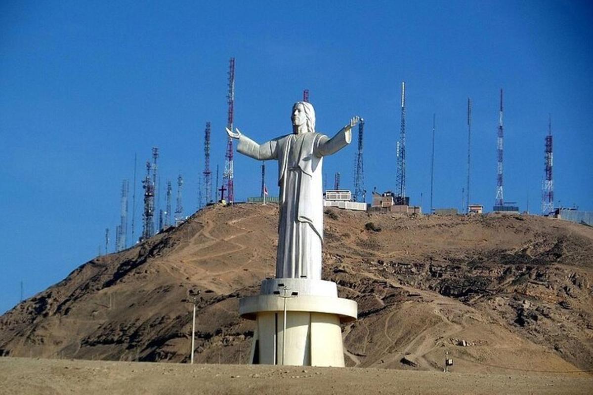 una statua di Cristo Redentore di fronte a una montagna