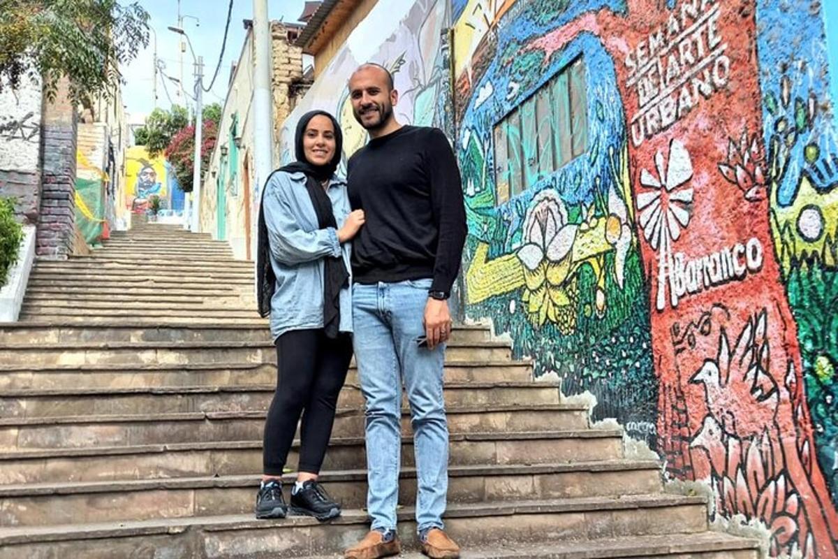 un uomo e una donna in piedi sulle scale davanti a un muro