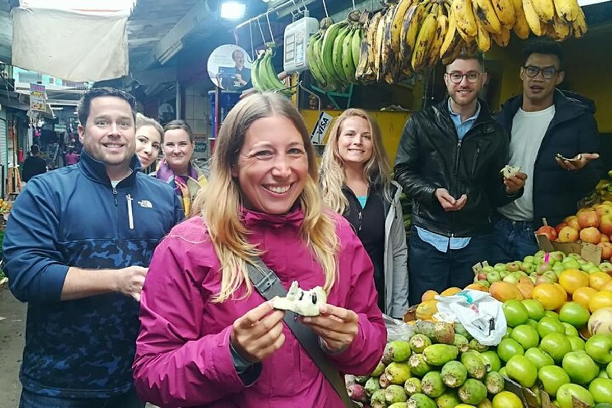 un gruppo di persone in piedi in un mercato con la frutta