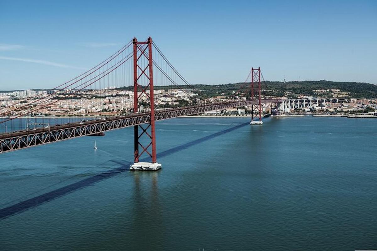 uma ponte vermelha na água com uma cidade
