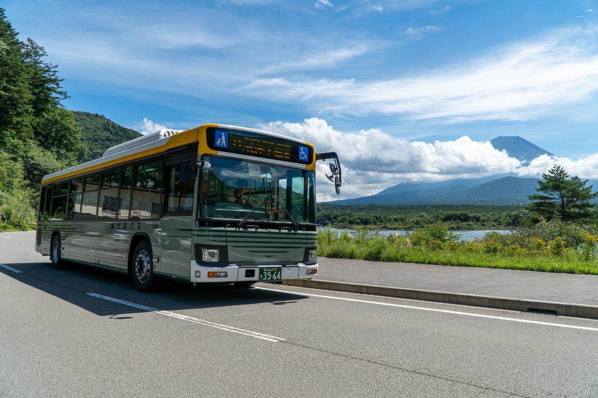 a bus driving down a road with mountains in the background