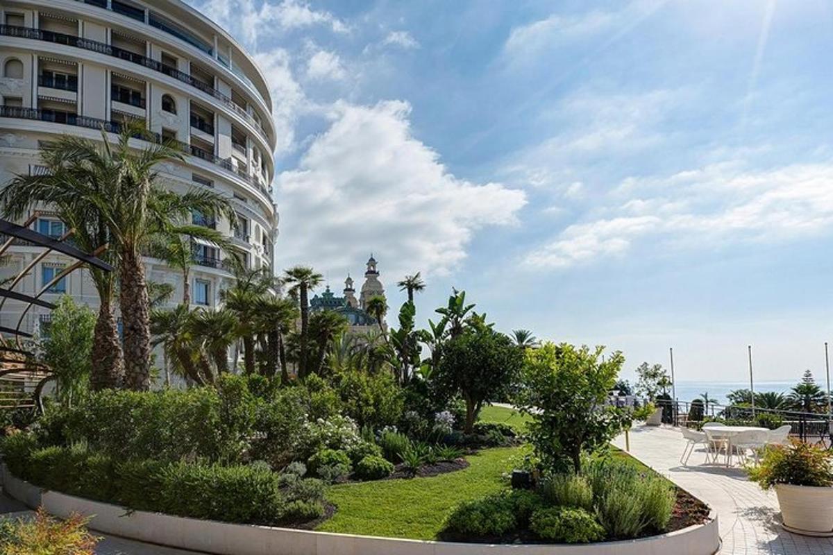 un edifici amb arbres i plantes davant d'un edifici