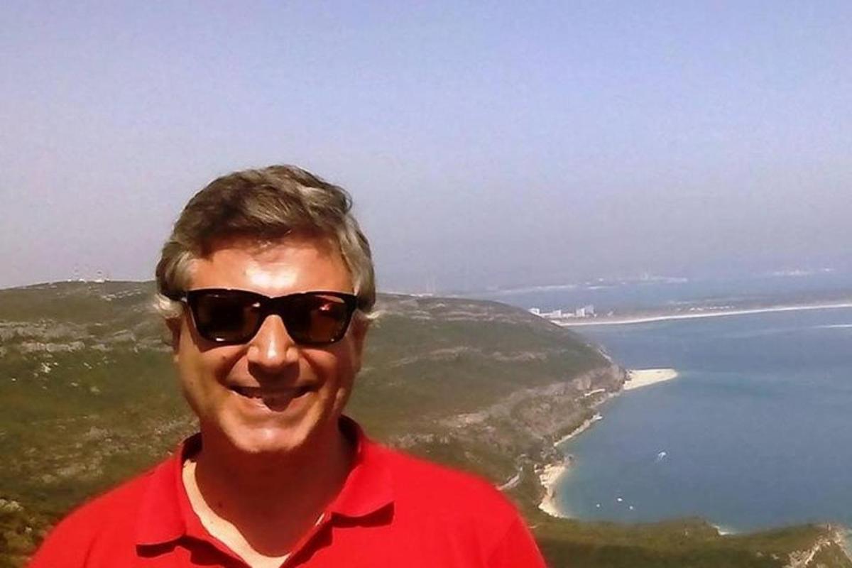 чоловік у сонцезахисних окулярах стоїть на березі океану