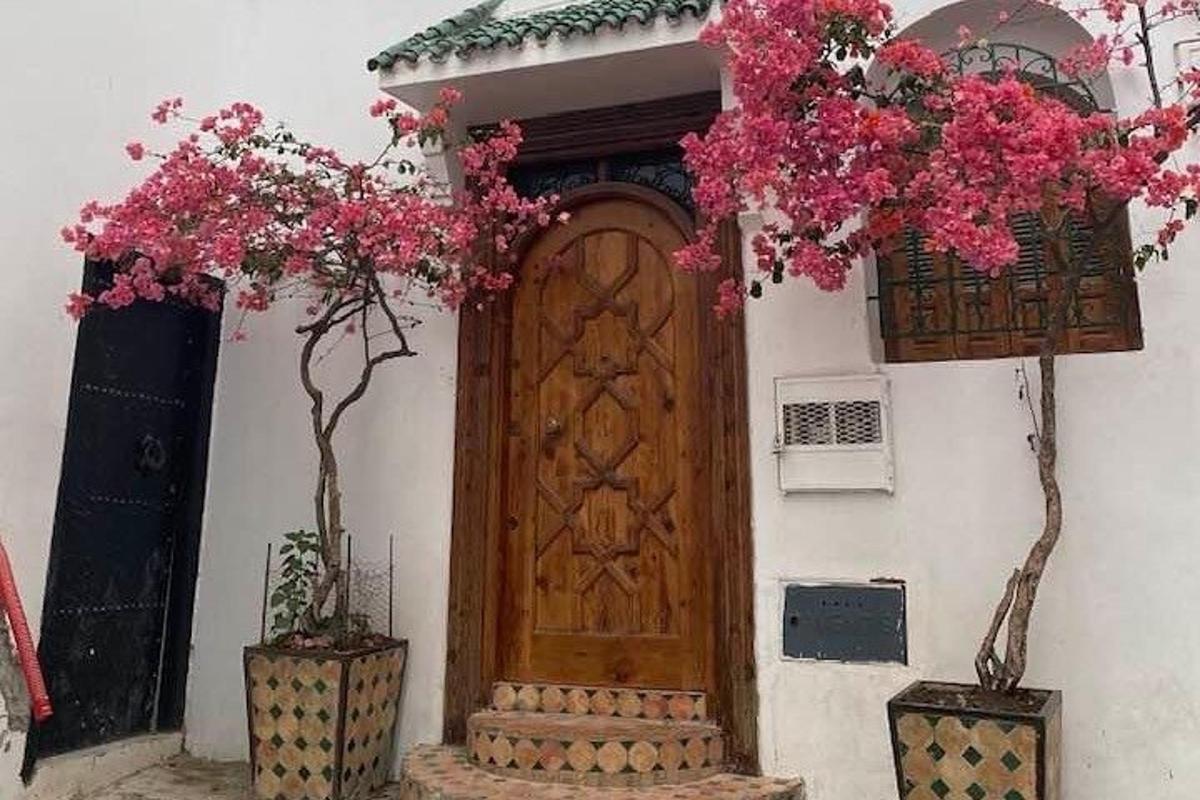 một ngôi nhà có cửa gỗ và hoa trên đó