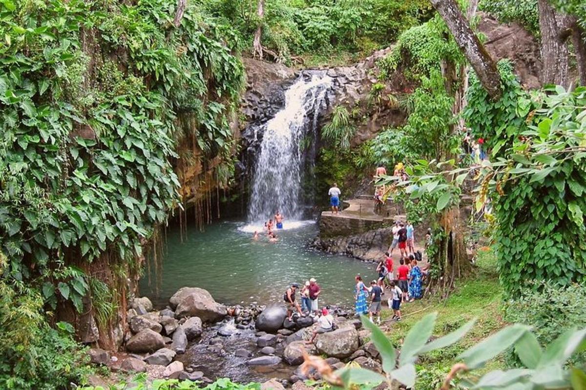 a group of people in a river with a waterfall