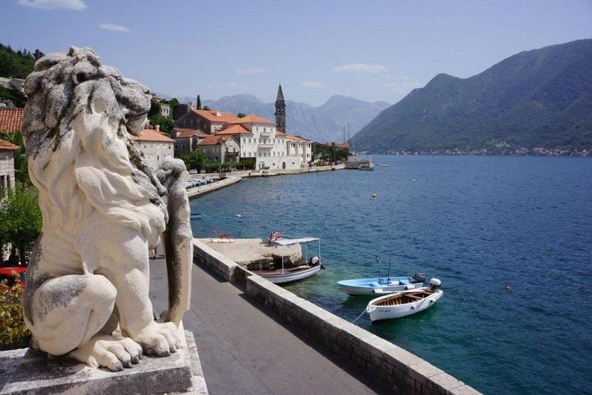a statue of a lion looking out over a body of water