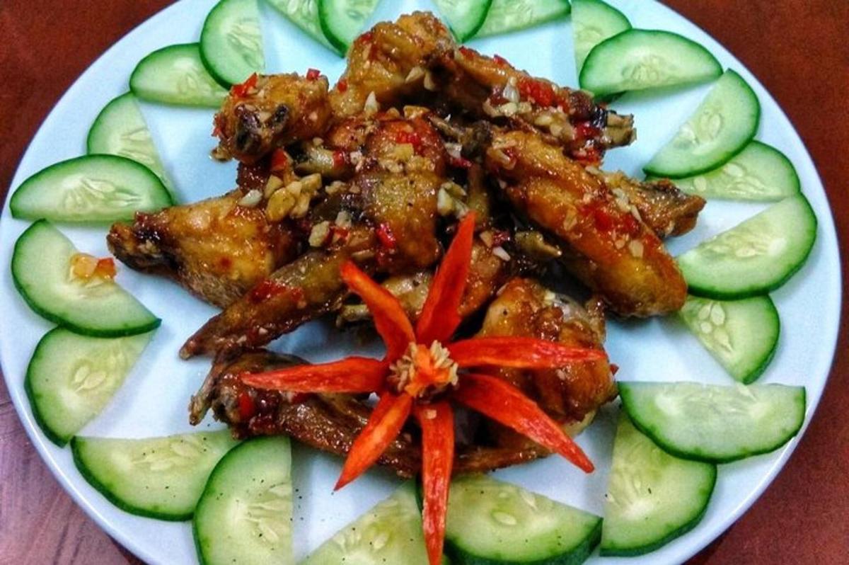 тарілка їжі з огірками та курячими крильцями