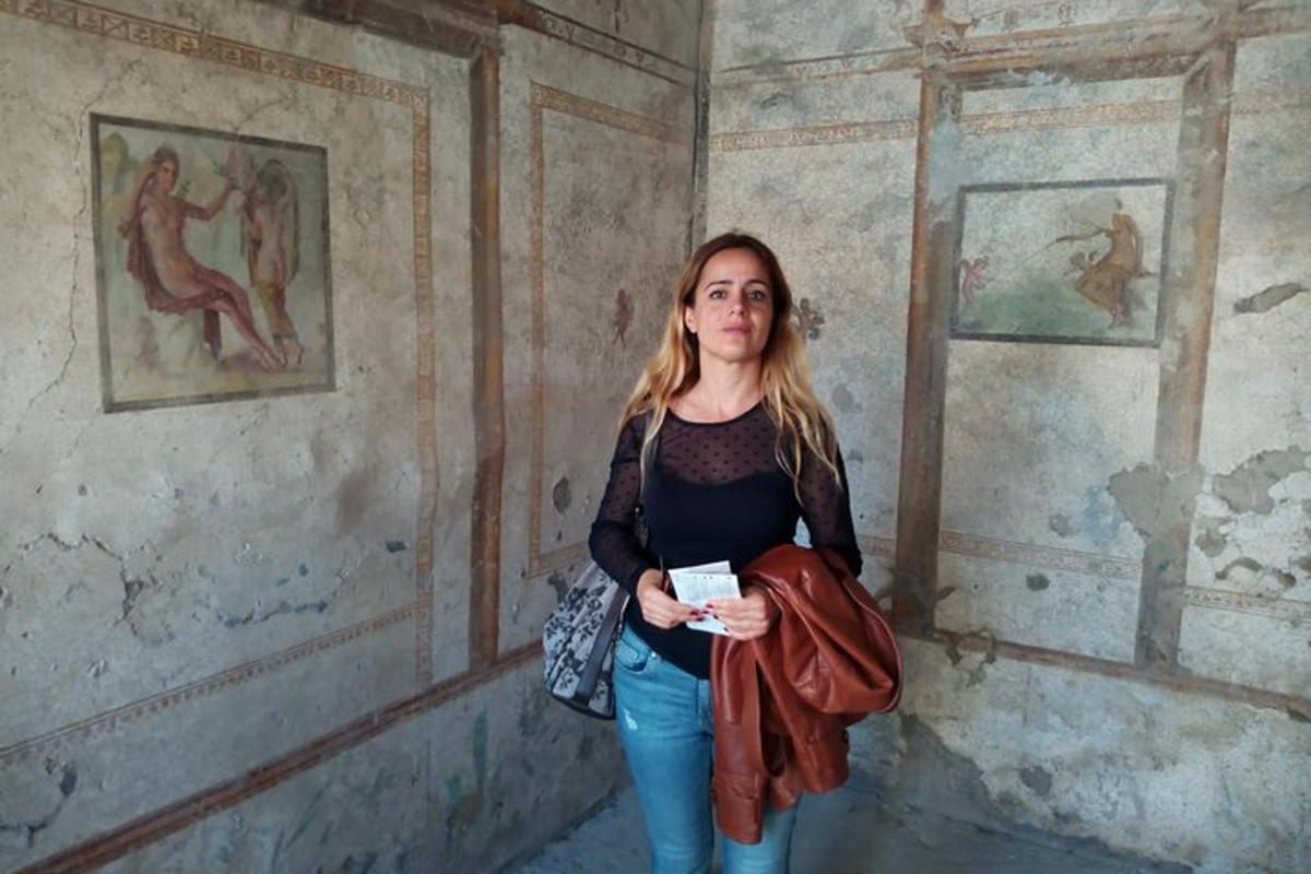 una dona dreta en una habitació amb quadres a la paret