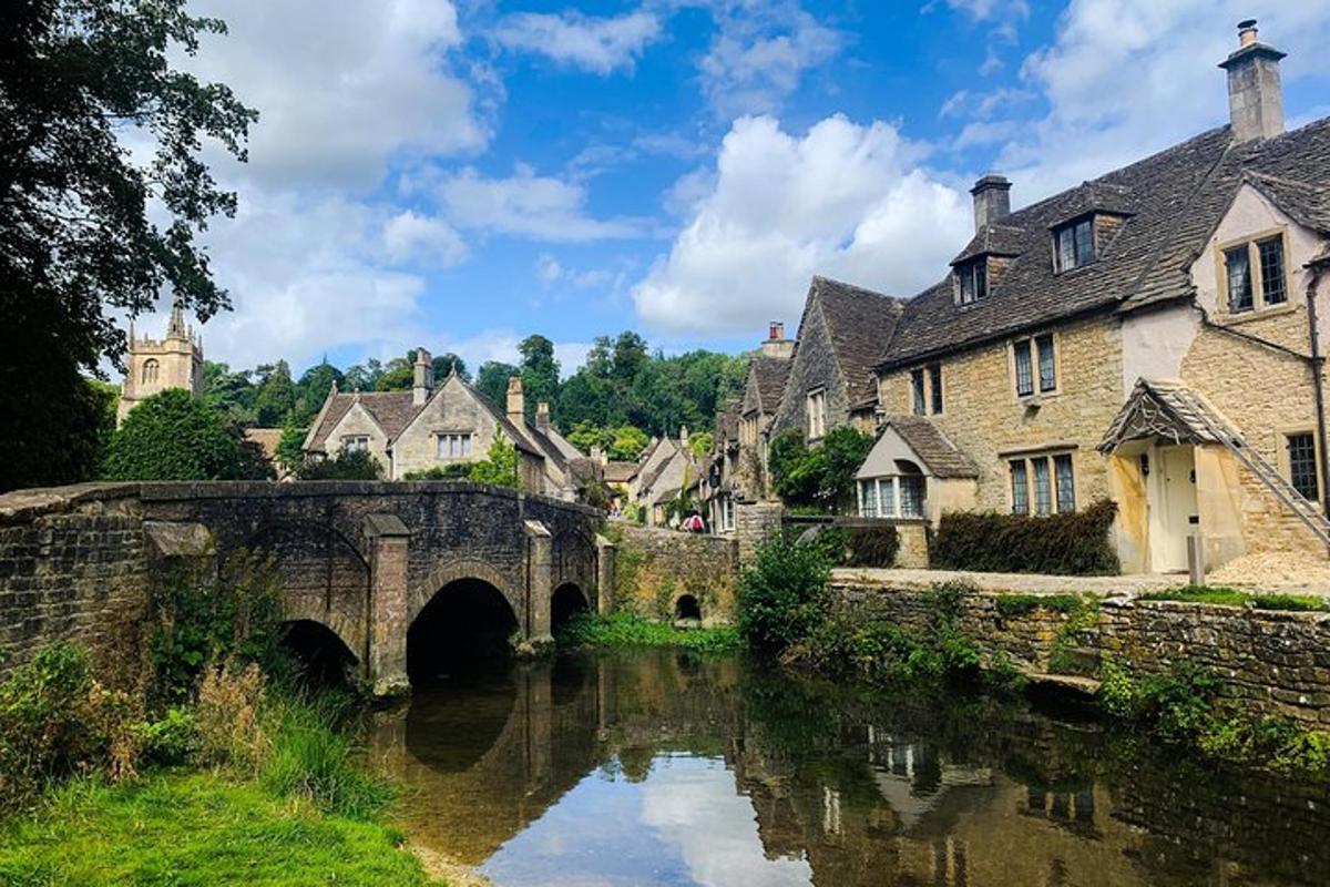 an old stone bridge over a river in a village