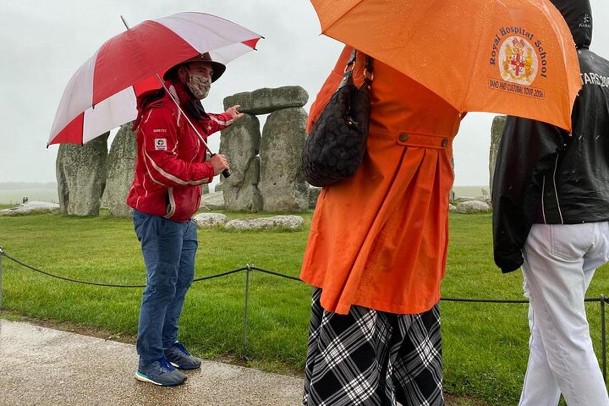 a group of people standing in the rain with umbrellas