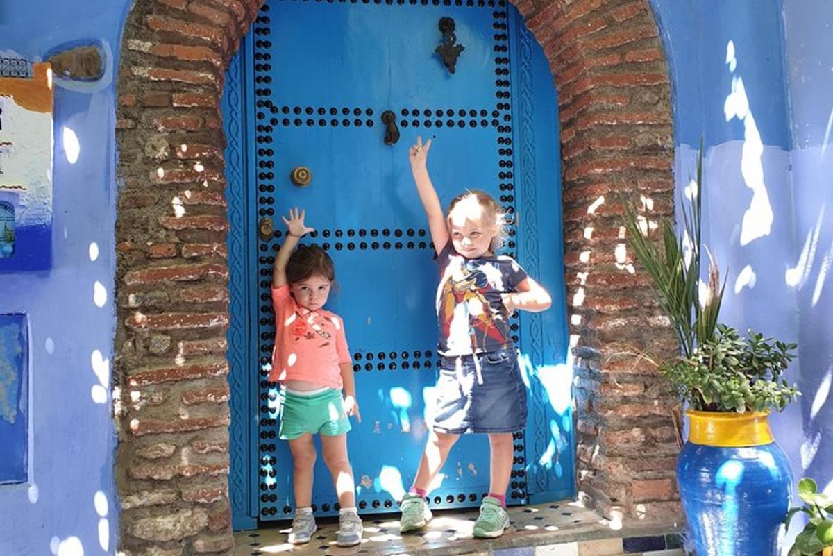 due bambini in piedi davanti a una porta blu