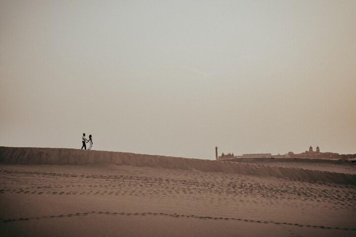 dos personas caminando por la arena en el desierto