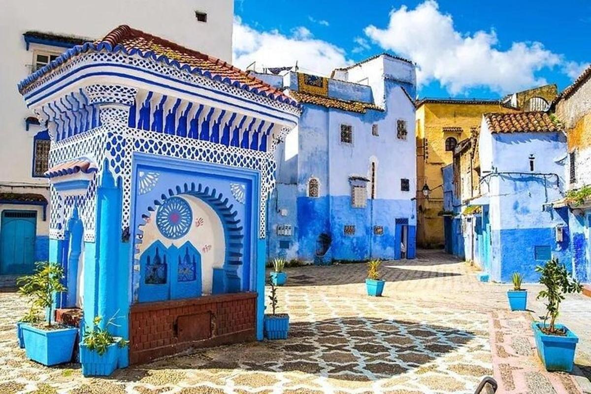 un edificio blu e bianco con un arco in un cortile