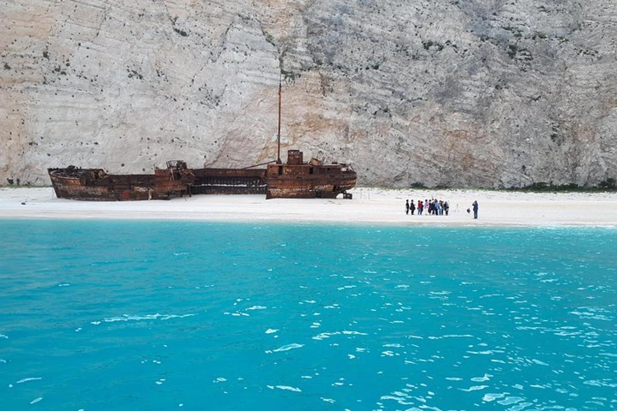 an old boat sitting on a beach near the water