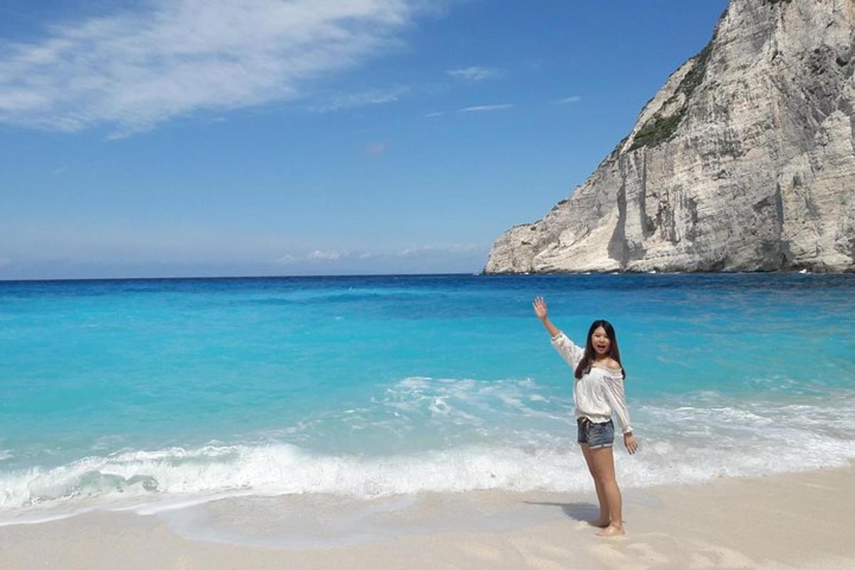 a woman standing on the beach with her hand in the air