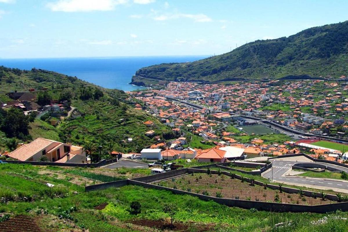 uma vista aérea de uma cidade em uma colina com o oceano