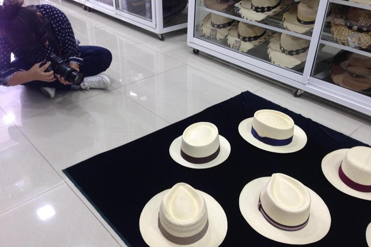uma mulher tirando uma foto de uma pilha de chapéus no chão