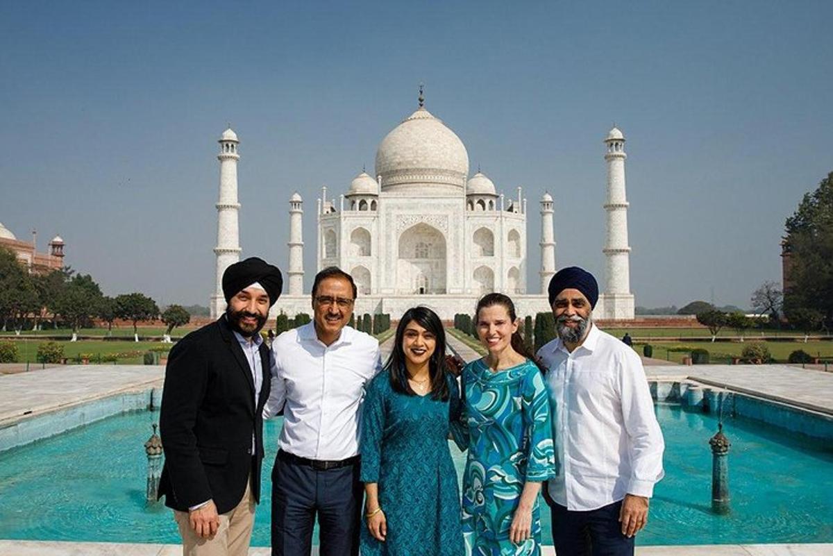 un gruppo di persone in piedi davanti al Taj Mahal