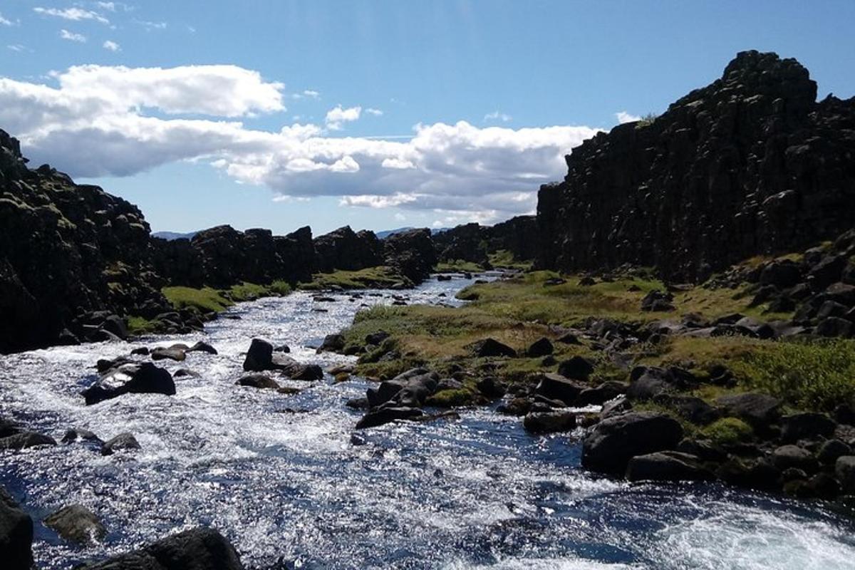 un fiume con rocce in mezzo a una montagna