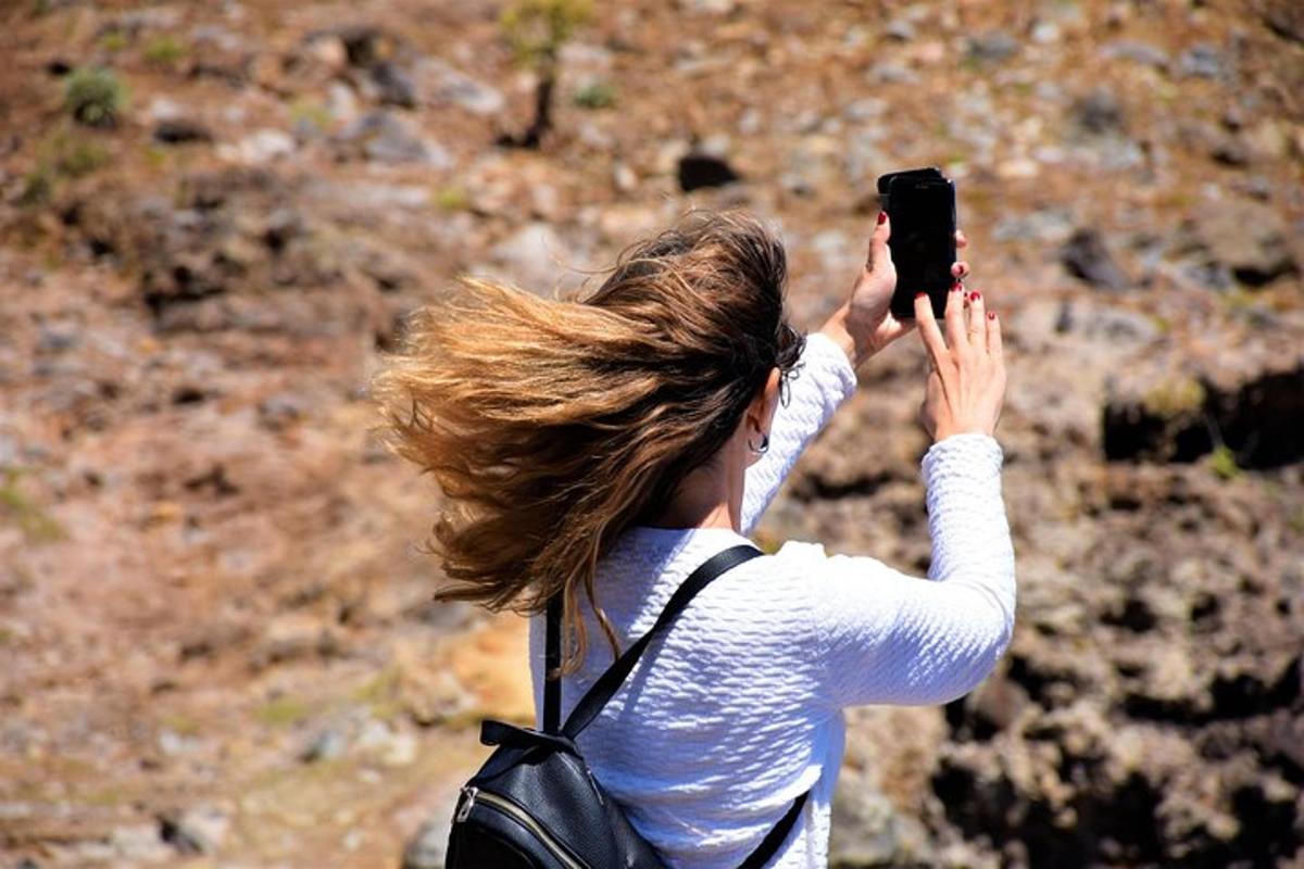 žena fotící se mobilním telefonem