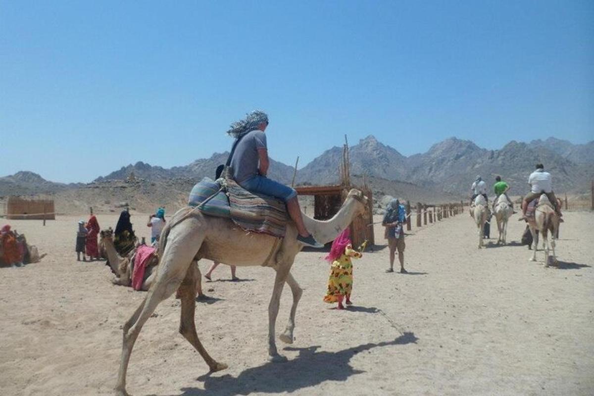 un uomo che cavalca un cammello nel deserto