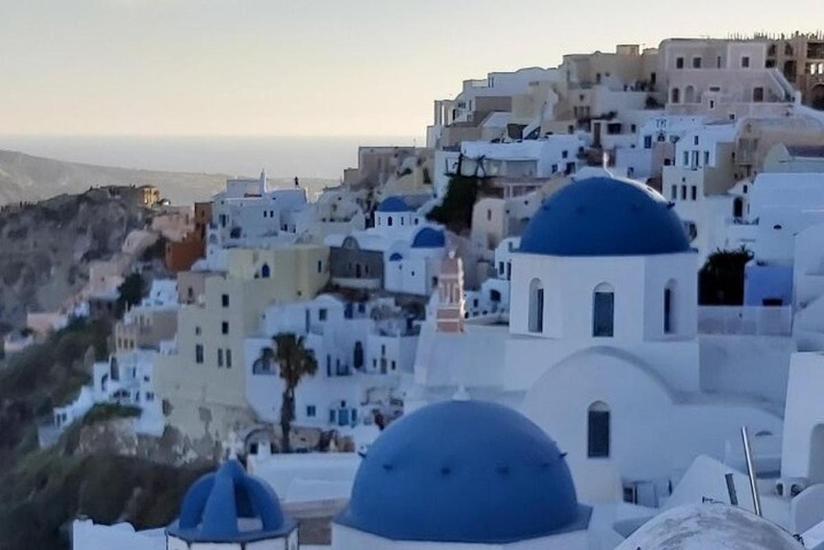 Una vista de un pueblo con edificios blancos y cúpulas azules.