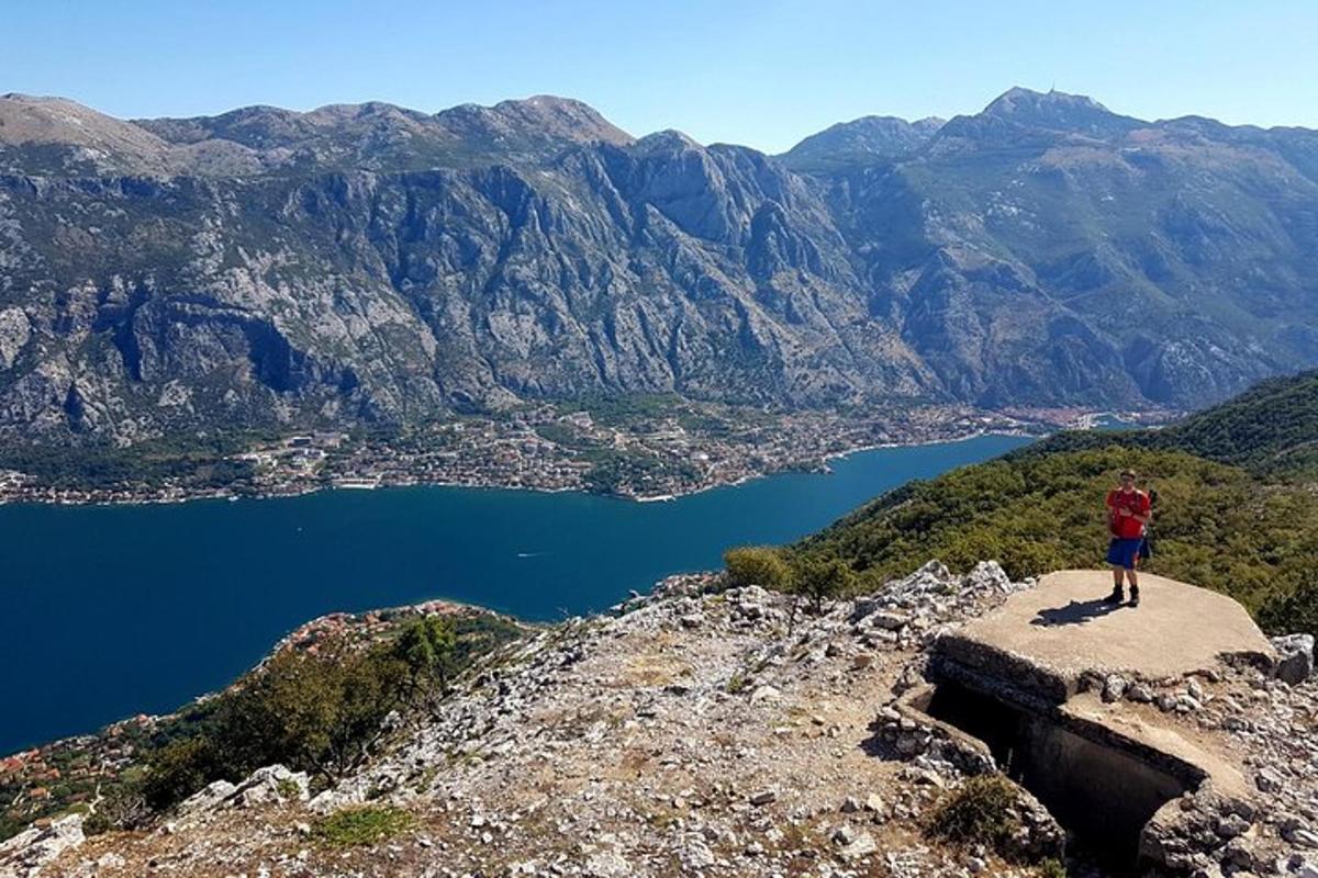 un uomo in piedi sul bordo di una montagna che domina un lago