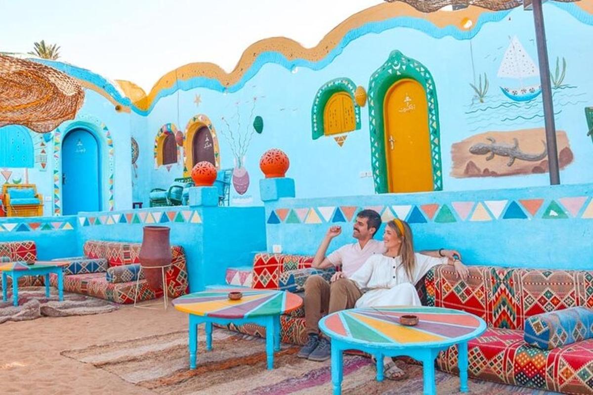a man and woman sitting on couches in front of a blue wall