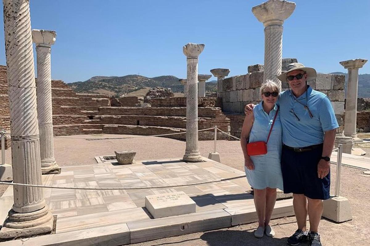 a man and a woman standing in front of some columns
