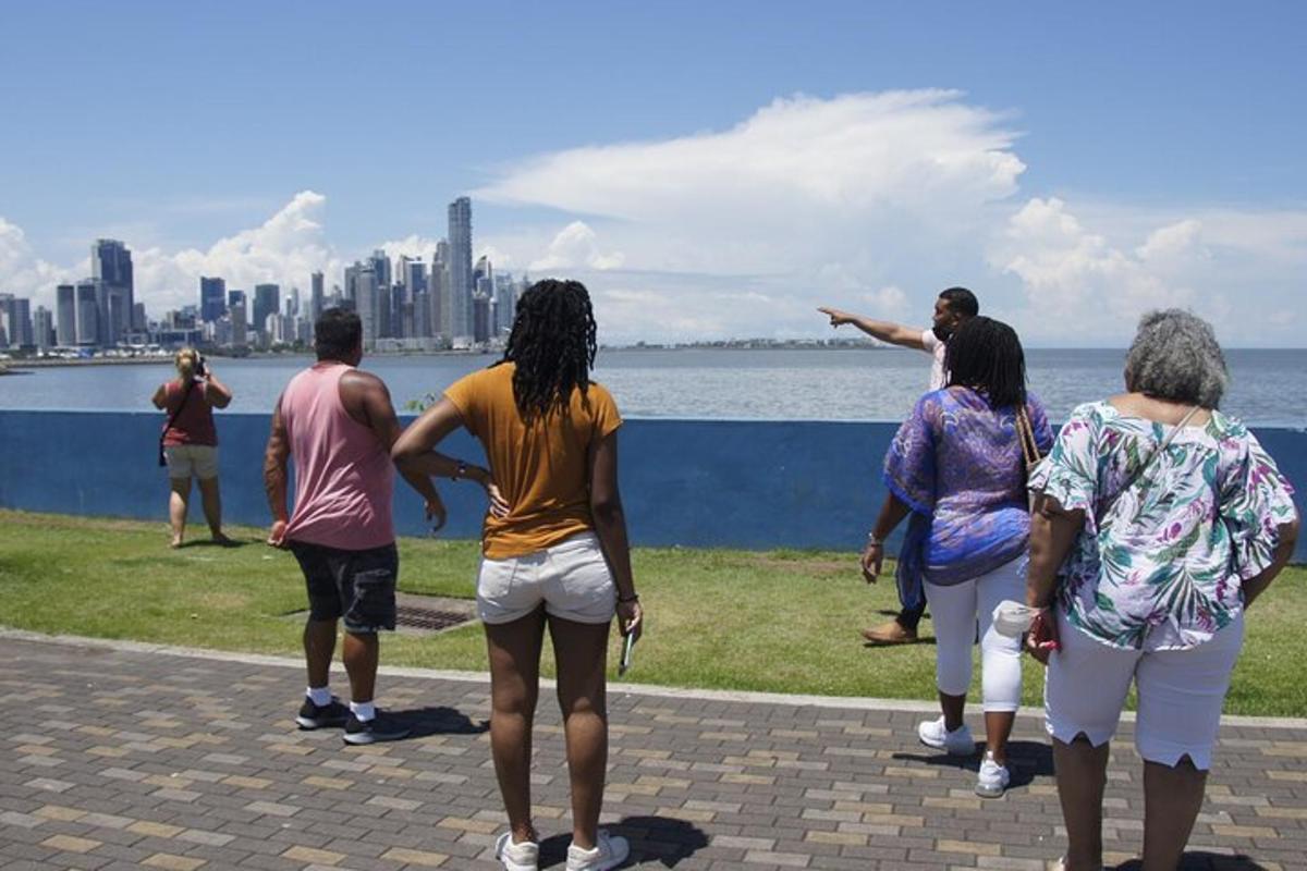 a group of people standing on the grass near the water